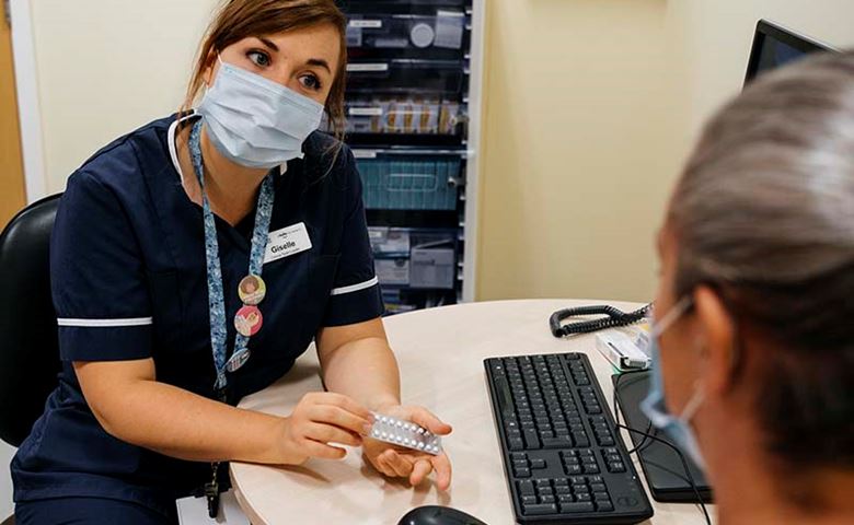 MSI UK nurse wearing mask holding contraception pills