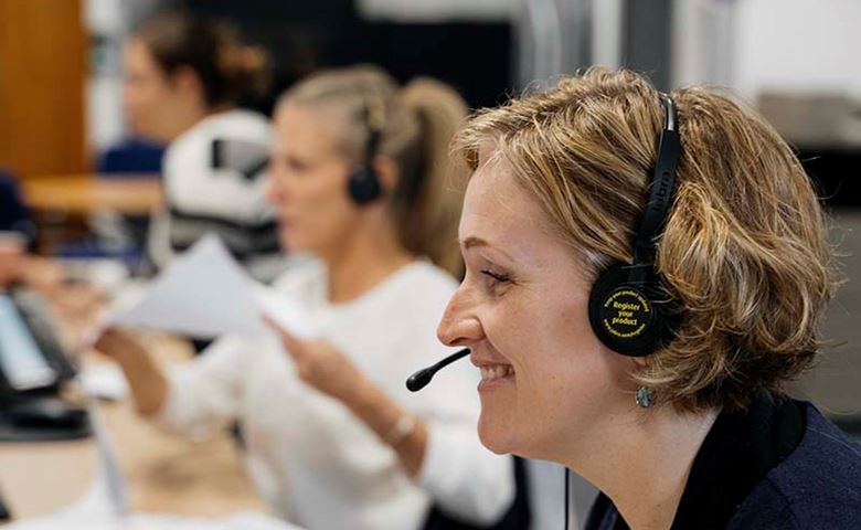 MSI UK call center agents smile looking at screen and wearing headsets
